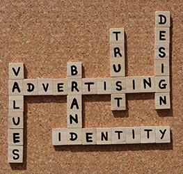 merk identiteit met 3d holografie. Afbeelding toont een scrabble met de woorden waade, advertising, merken, vertrouwen, identiteit en design