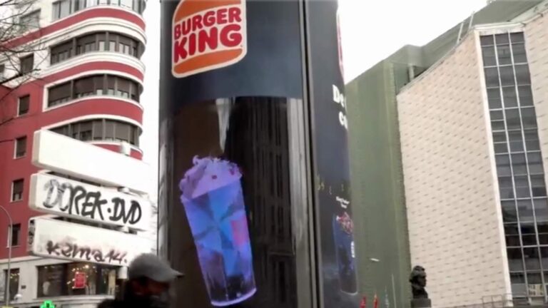 Een holografische advertentie trekt aandacht op een druk plein.