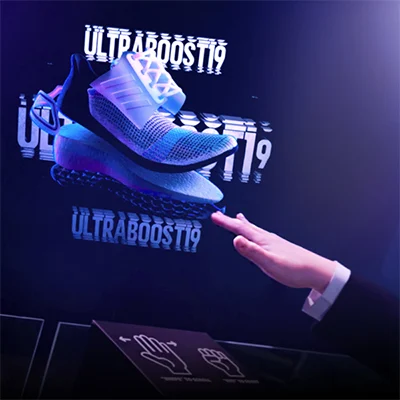 Een klant bekijkt een holografische display met 3D-productvisualisatie in een winkel.