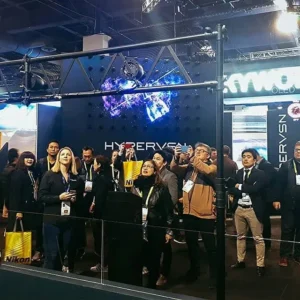 Bezoekers staan rond een stand met holografische 3D-presentatie op een evenement.
